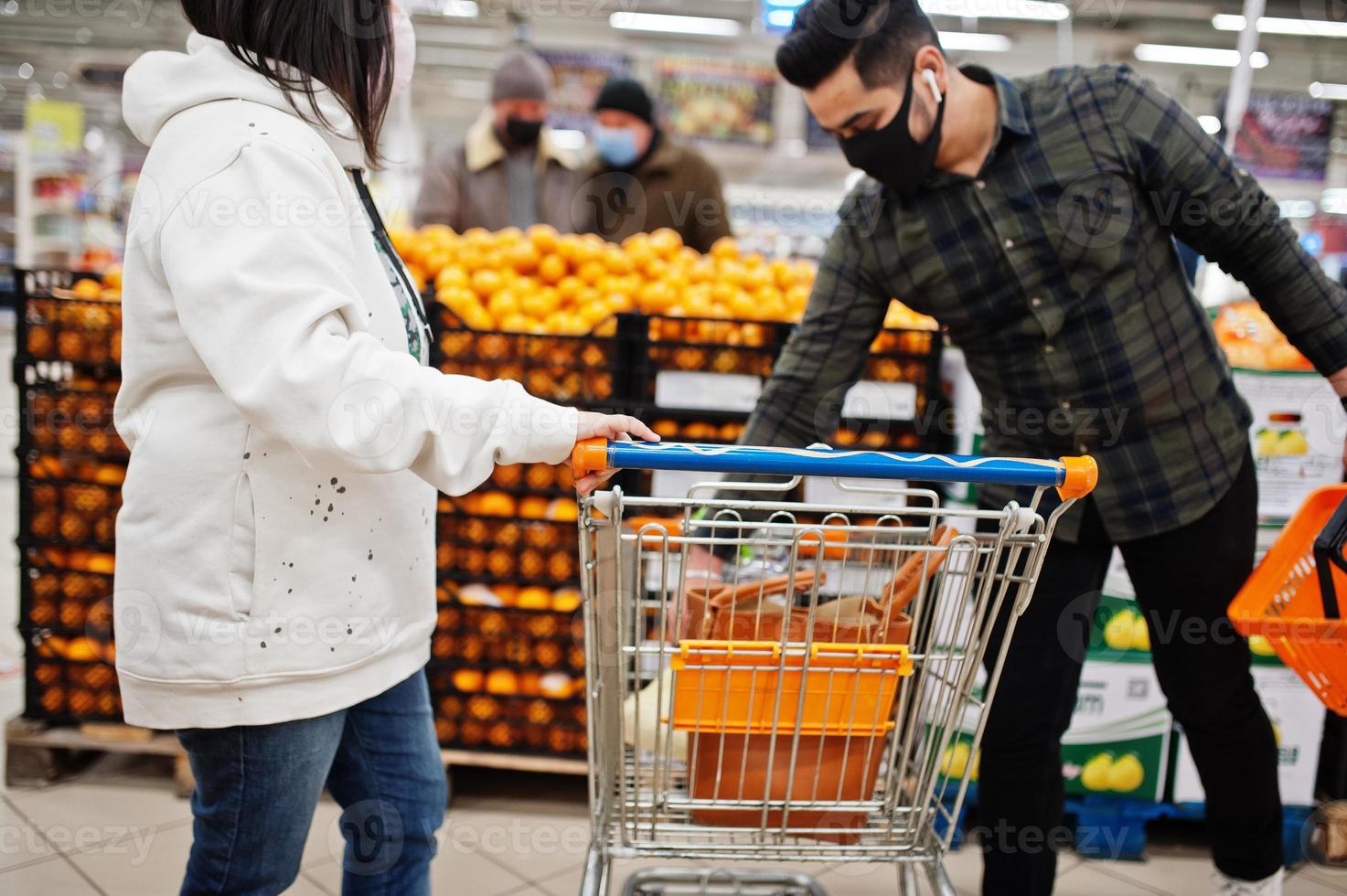 Asian couple wear in protective face mask shopping together in supermarket during pandemic. photo