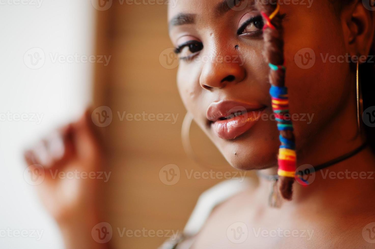 primer plano retrato de una encantadora mujer afroamericana con rastas en traje de leopardo en el café. hermosa chica joven negra de moda fresca interior. foto