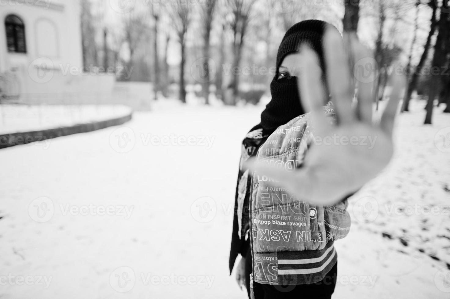 African muslim woman wear in black hijab scarf pose in winter day at Europe and show stop sign by hand. photo