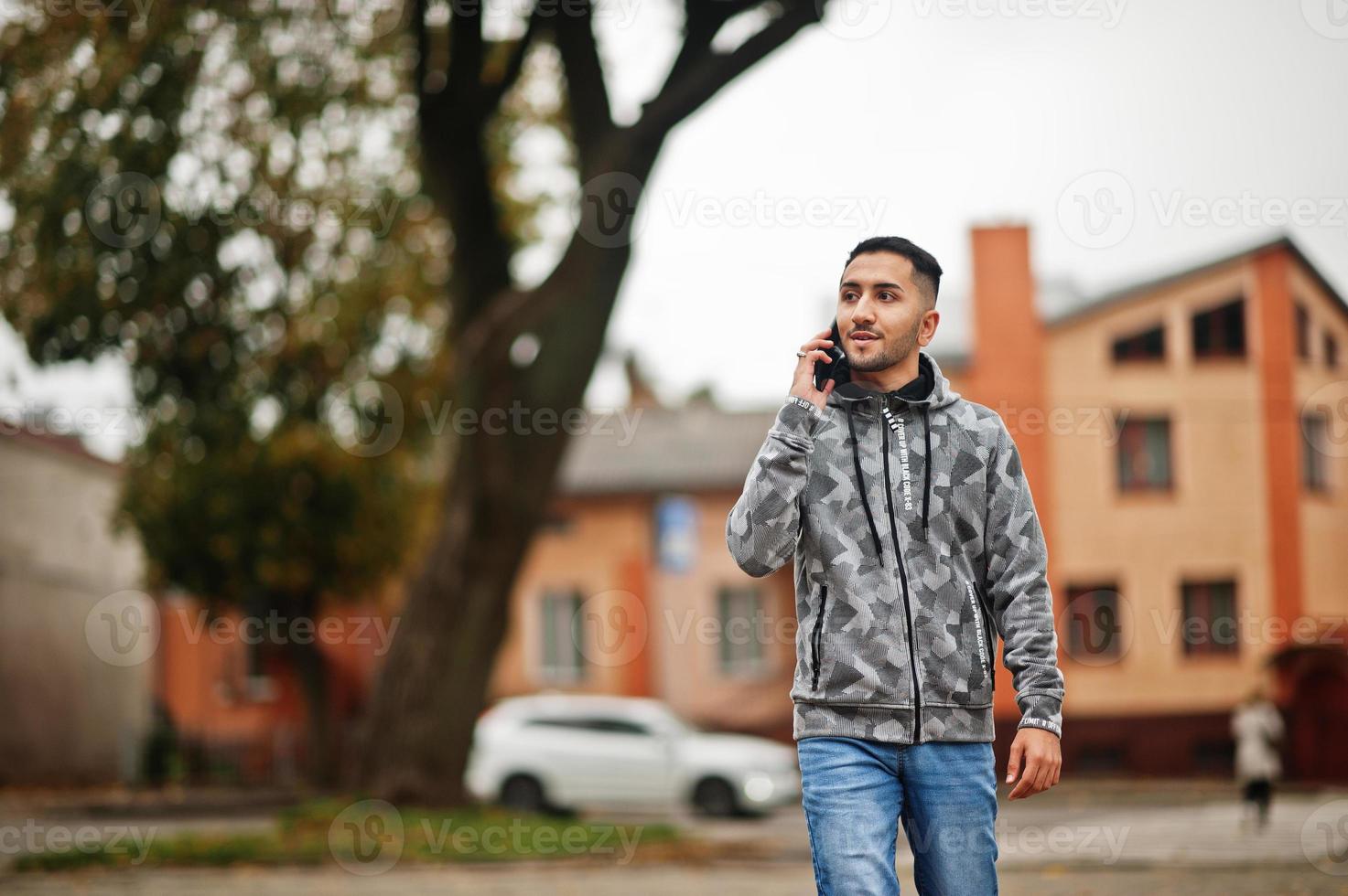 Student kuwaiti man wear at hoodie, speaking by phone. photo