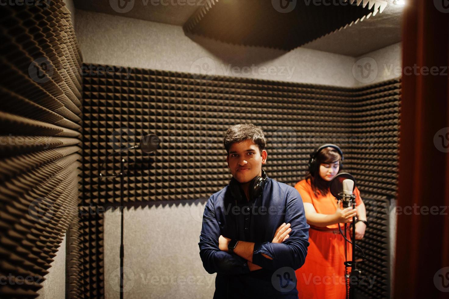 jóvenes cantantes de dúo asiáticos con micrófono grabando una canción en un estudio de grabación de música. foto