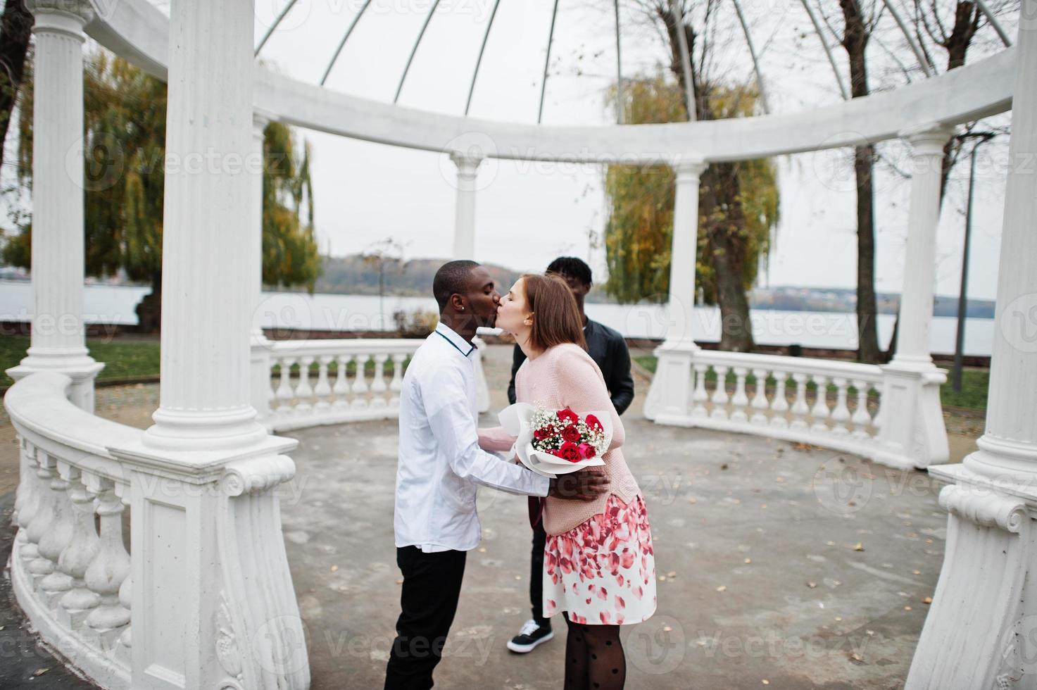 Wedding engagement ceremony with pastor. Happy multiethnic couple in love story. Relationships of african man and white european woman. photo