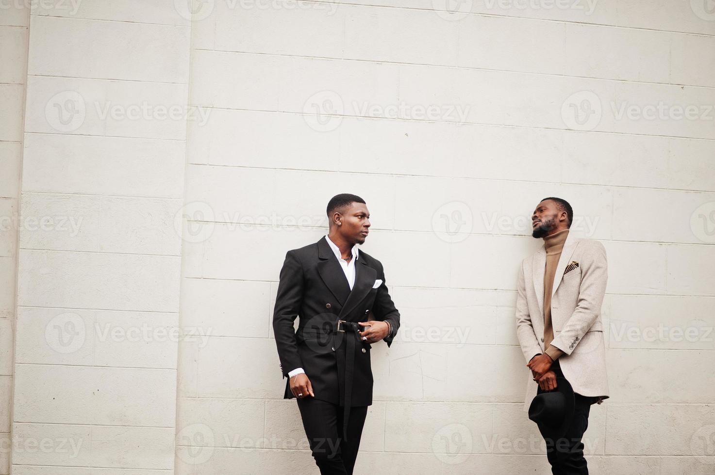 dos hombres negros de moda. retrato de moda de modelos masculinos afroamericanos. llevar traje, abrigo y sombrero. foto