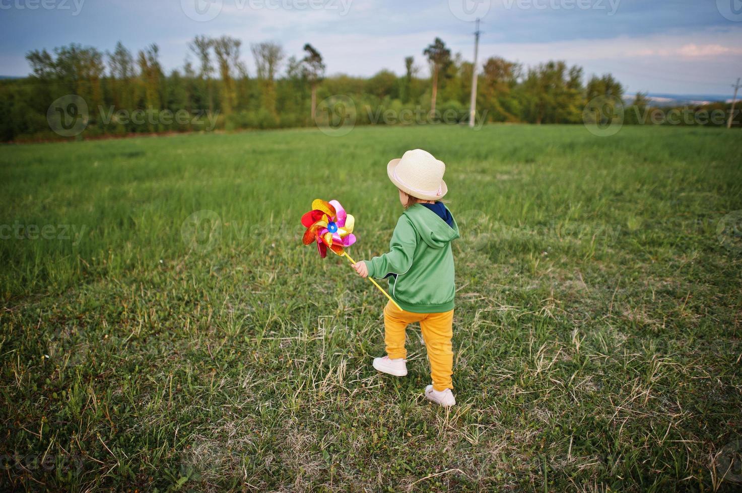 Babay girl with pinwheel at meadow. 11015043 Stock Photo at Vecteezy