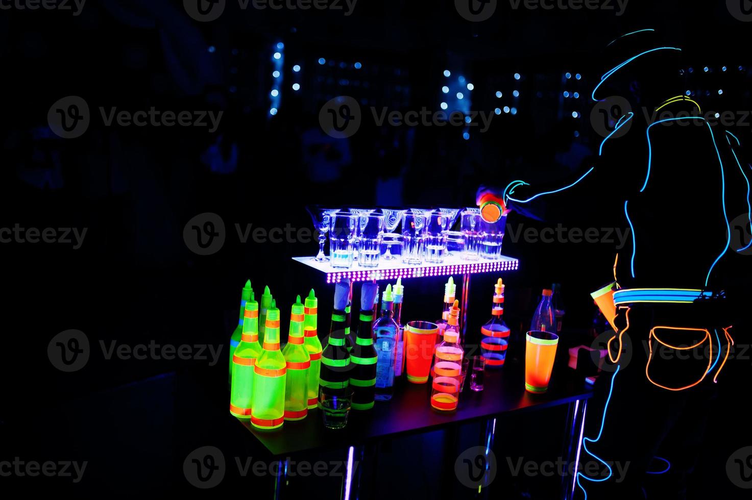 barman profesional y show de luces led. silueta de barman moderno agitando una bebida en el bar de cócteles nocturno. foto