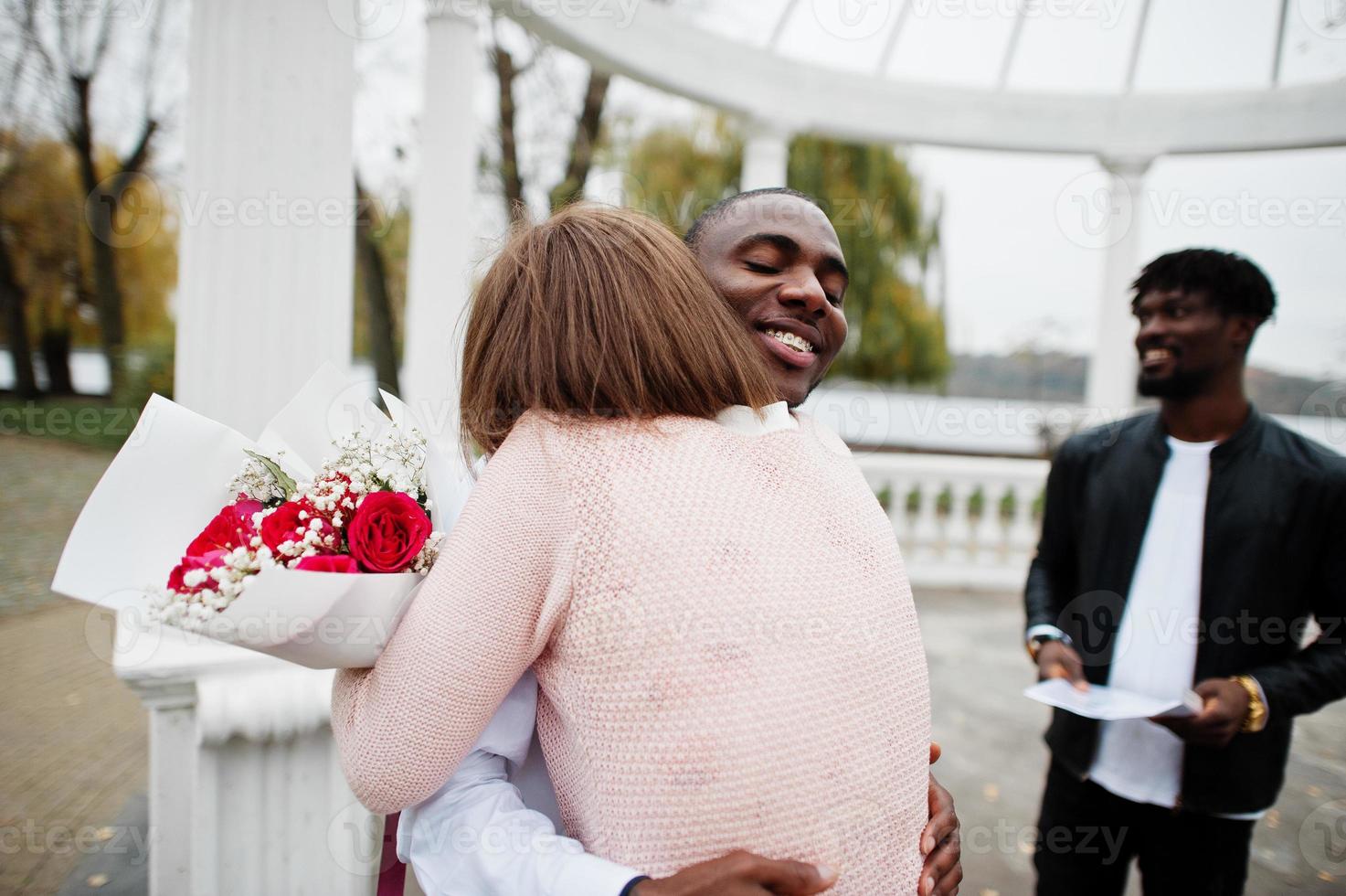 Wedding engagement ceremony with pastor. Happy multiethnic couple in love story. Relationships of african man and white european woman. photo