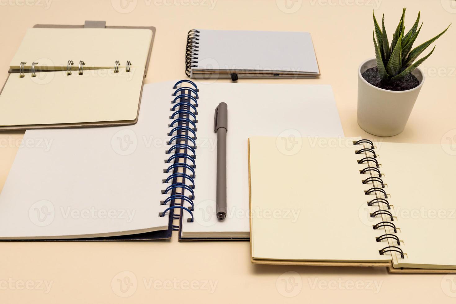 Eco friendly notebooks for office, with copy space and pen made of recycled paper on a pastel background. photo