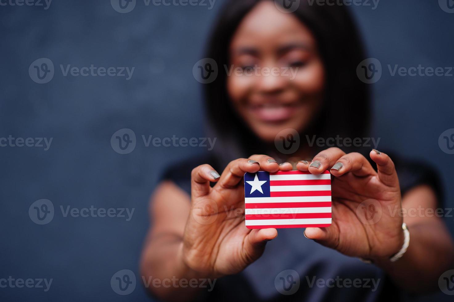 Proud to be liberian. African woman hold small Liberia flag in hands. photo
