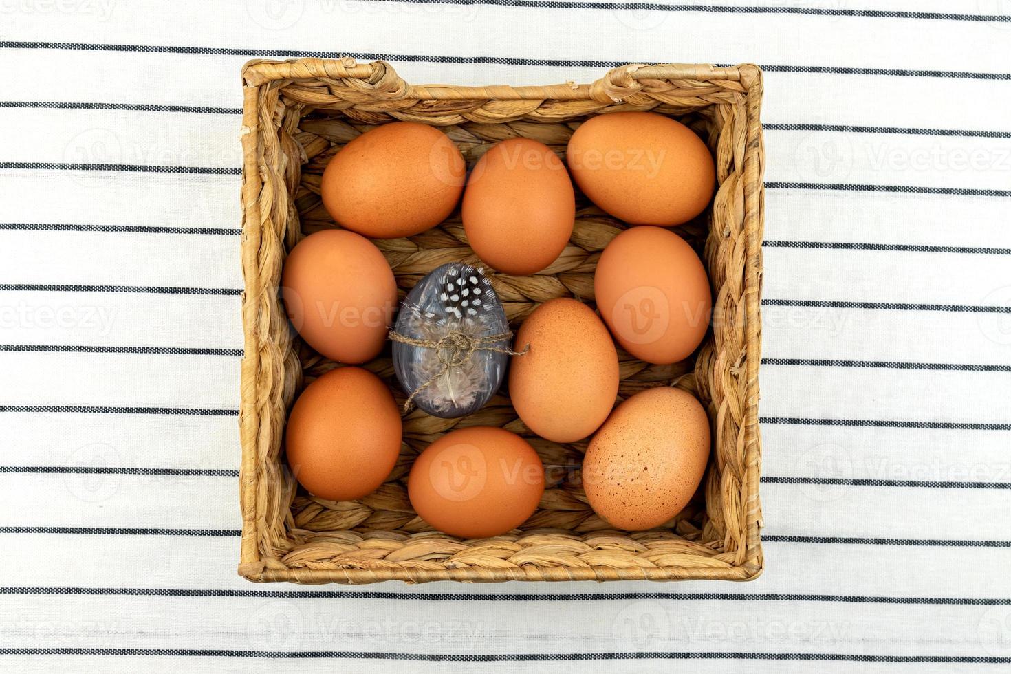 Zero waste easter background. No plastic concept. Minimal style. Beige water hyacinth box with brown chicken eggs on textile background. photo