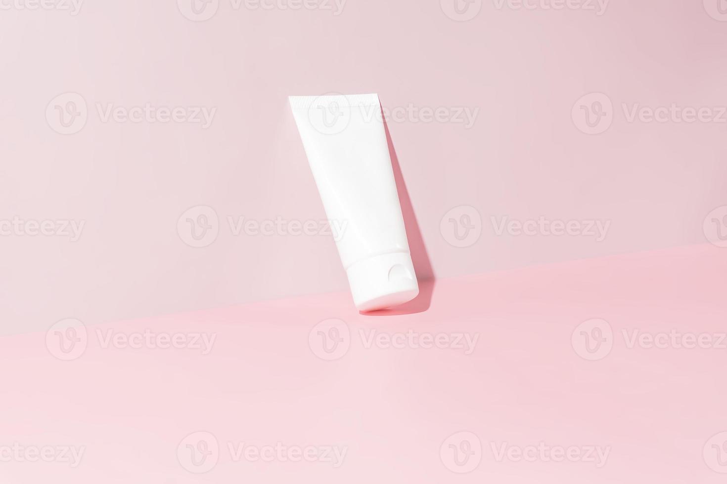 Face or hand cream in white plastic tube on pink background. Skin care concept. Mock up. Minimalism style. photo