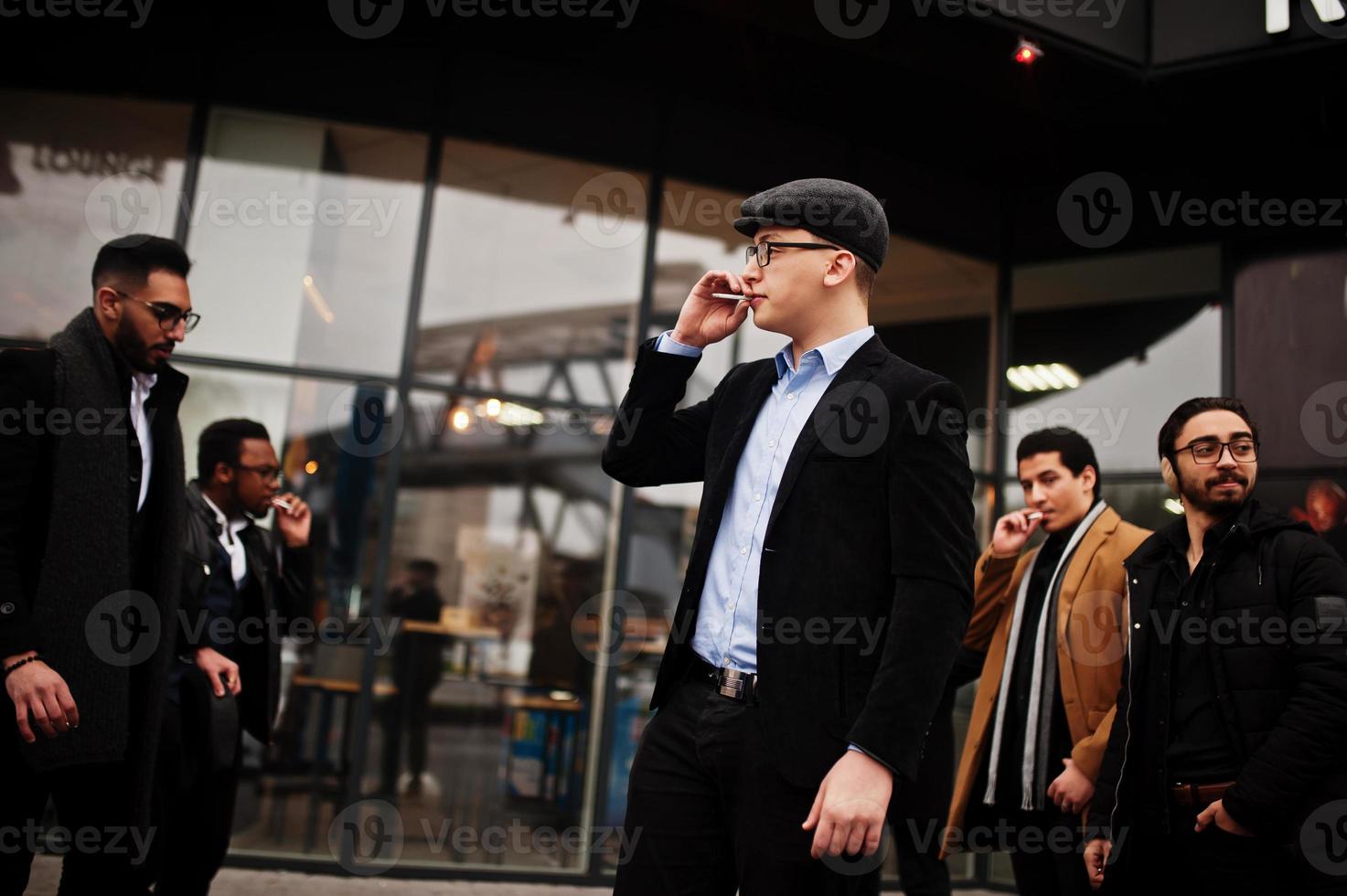 Group of handsome retro well-dressed man gangsters smoking outdoor. Multiethnic male bachelor mafia party. photo