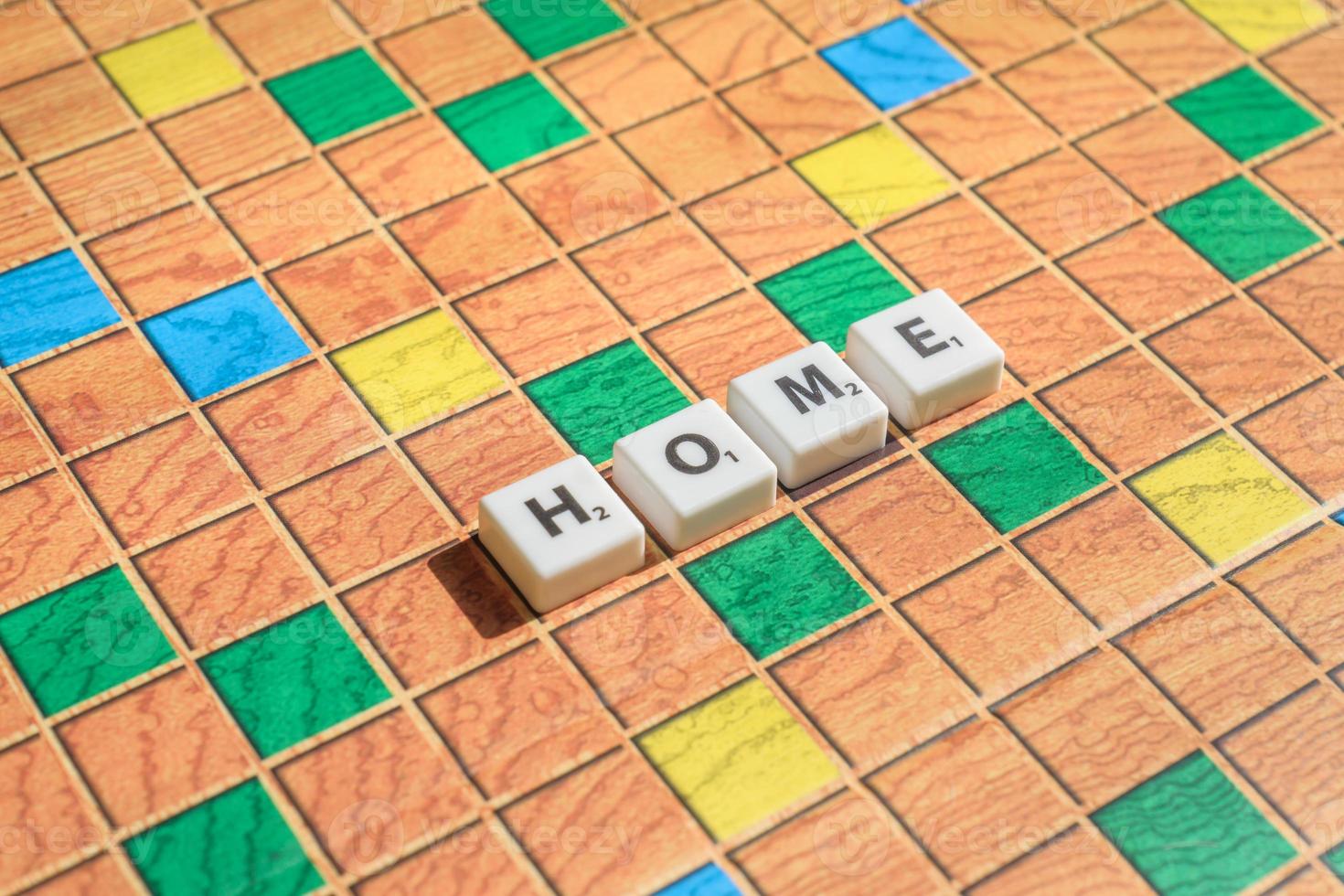 Scrabble game letters. Word home on game board photo