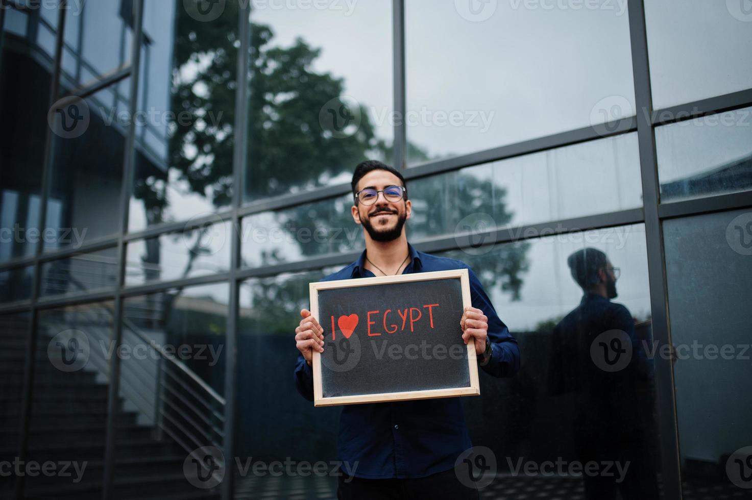 I love Egypt. Middle eastern man wear blue shirt, eyeglasses, hold board. photo