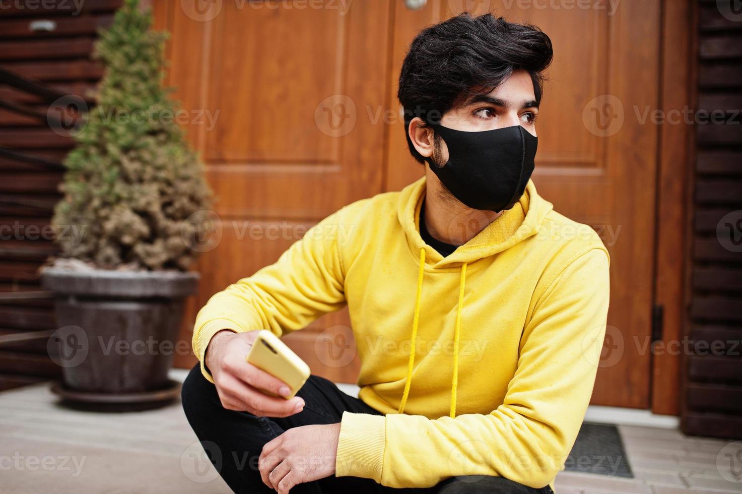 hombre indio joven hipster urbano en una sudadera amarilla de moda