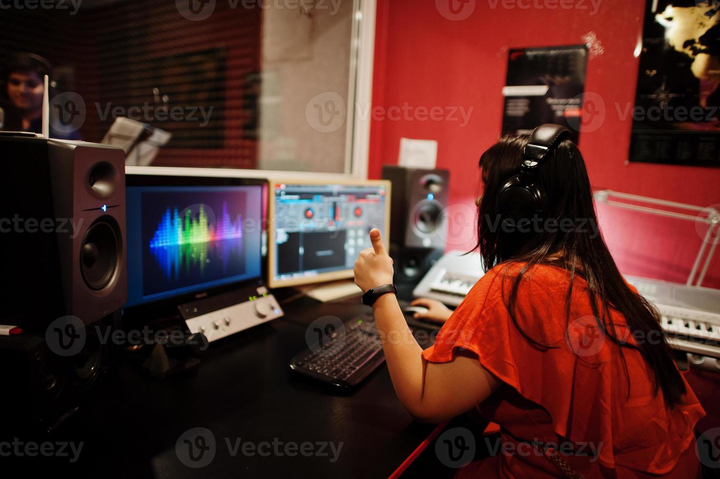 Young asian singer man with microphone recording song in record music studio with sound producer. photo