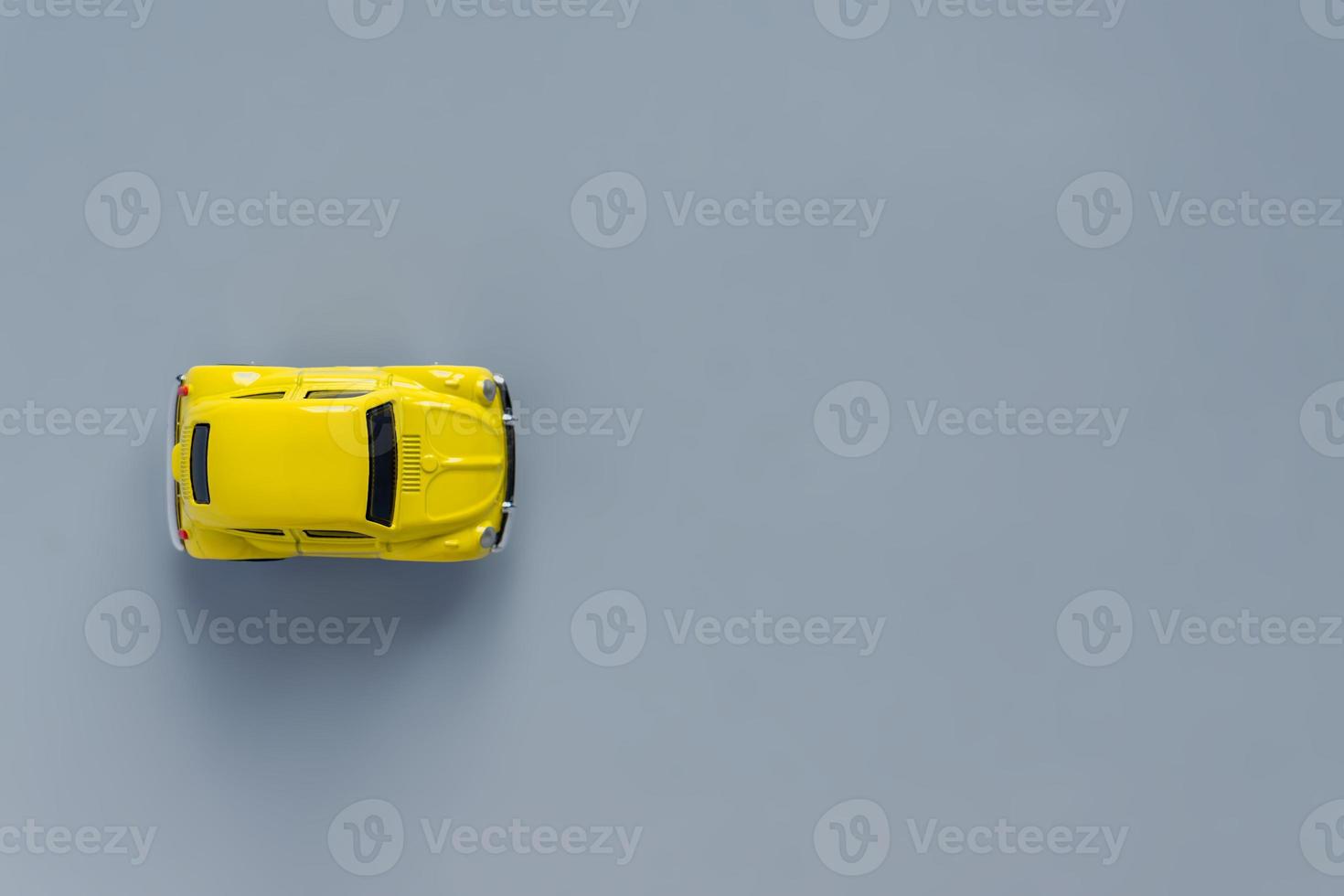 Flat lay in a trendy 2021 new colors. Illuminating Yellow and Ultimate Gray. Color of the Year 2021. Retro toy car on grey background with copy sapce photo