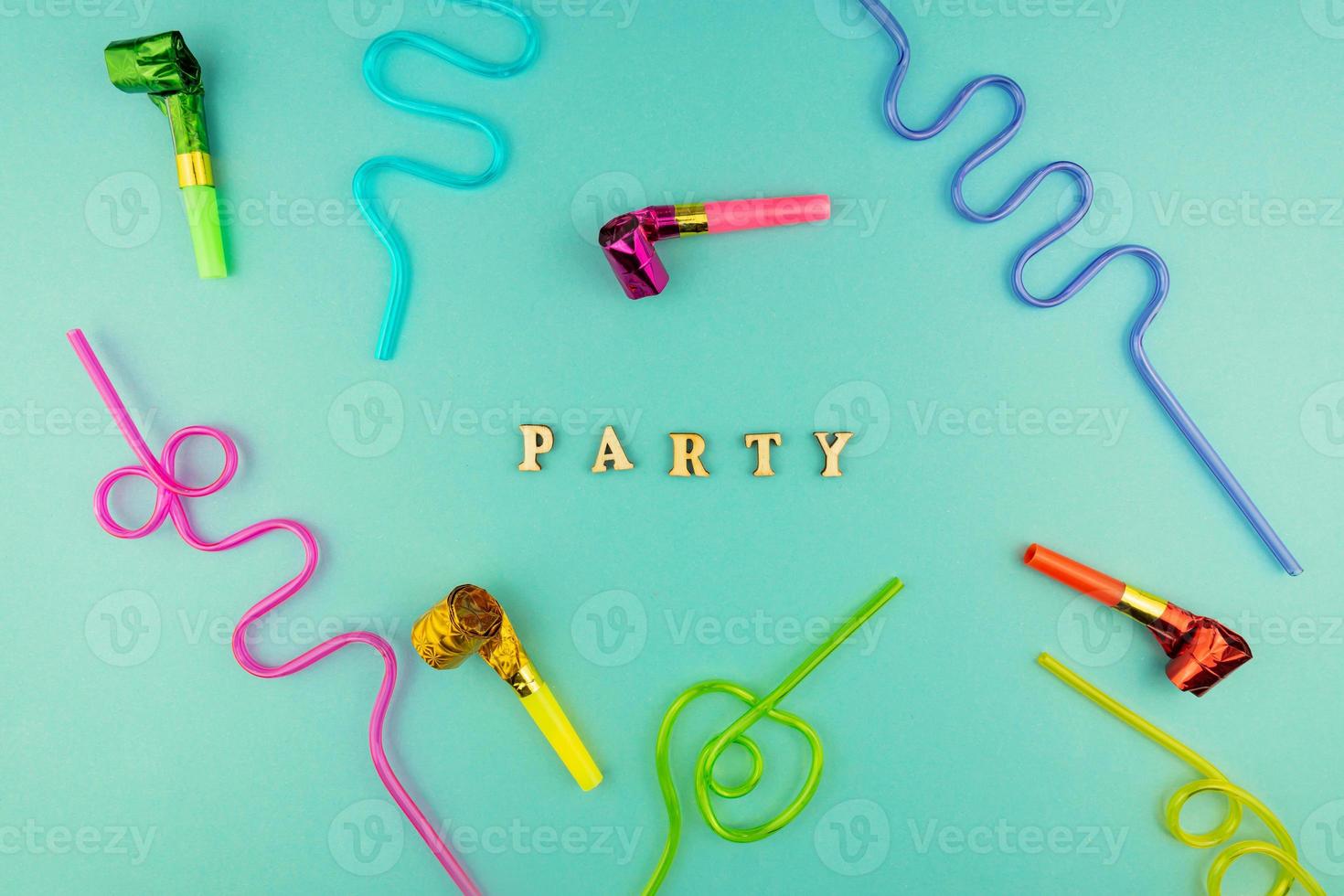 Bright festive party background - cocktail straws and party whistles on blue background. photo