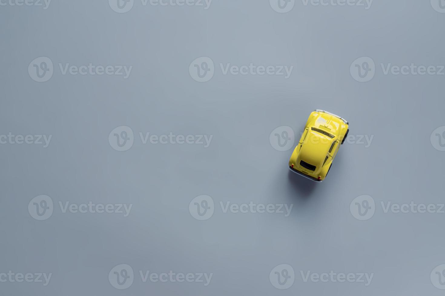 Flat lay in a trendy 2021 new colors. Illuminating Yellow and Ultimate Gray. Color of the Year 2021. Retro toy car on grey background with copy sapce photo