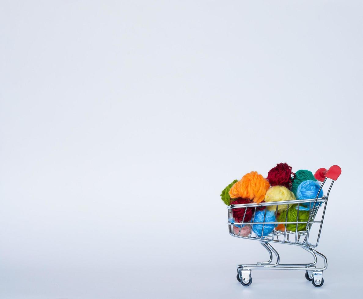 Trolley with yarn for knitting. Needlework. Hobbies and recreation. Colored threads on a white background. copy space, side view photo