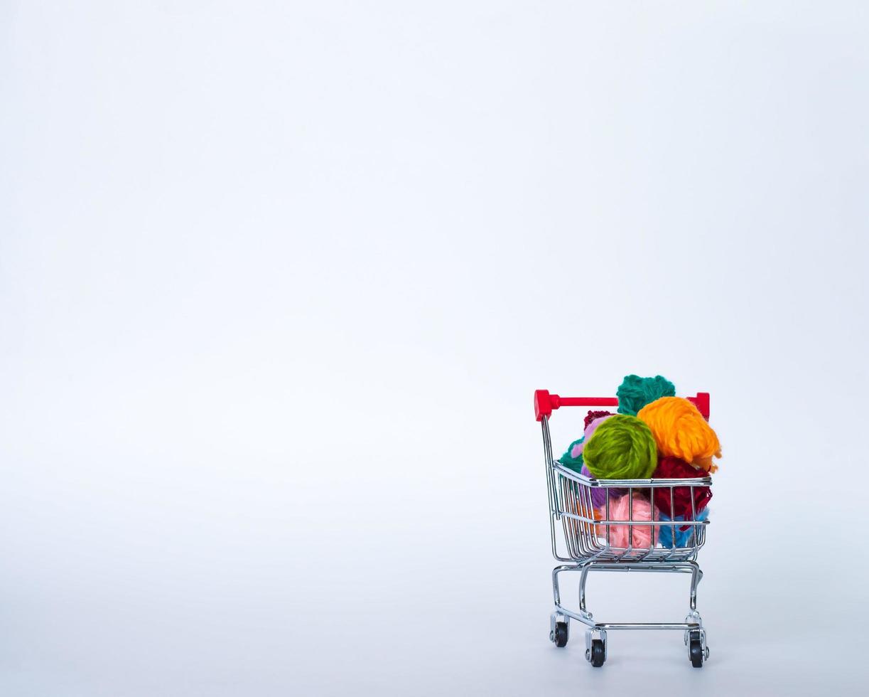 Trolley with yarn for knitting. Needlework. Hobbies and recreation. Colored threads on a white background. copy space, front view photo