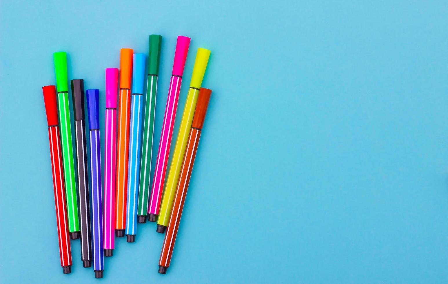 multicolored markers on a blue background. photo