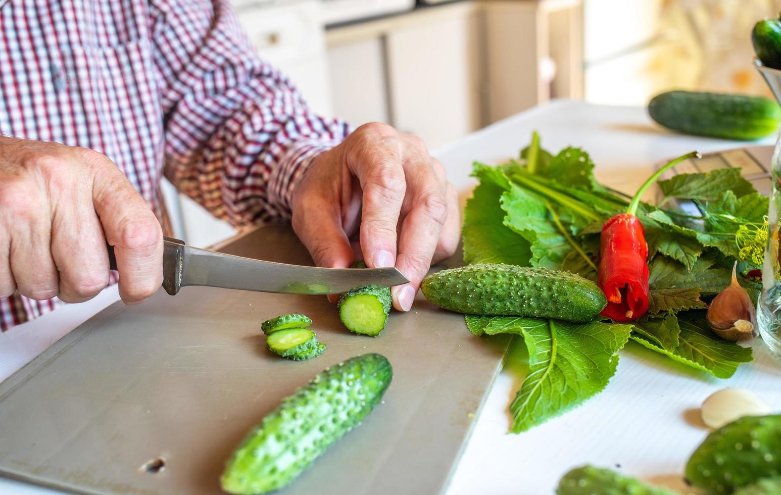 Modern male hands cutting cucumber salad, great design for any purpose. Fresh organic vegetable. Business concept. Modern design. Cooking healthy wholesome food. photo