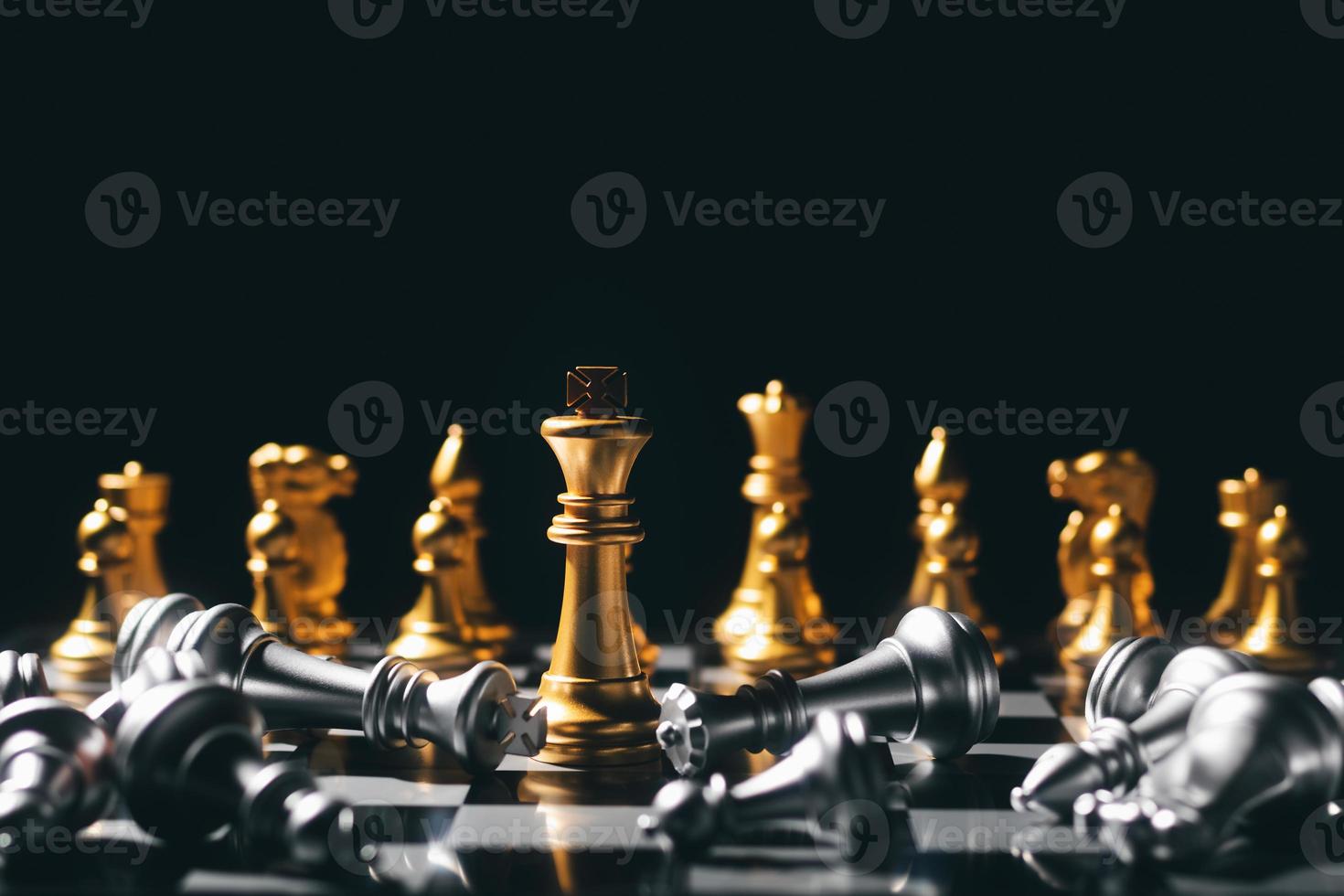 primer plano rey de pie sobre un tablero de ajedrez. hay un ajedrez cayendo al frente, liderazgo. desafíos del equipo de negocios de trabajo en equipo, ganadores de la industria global. foto