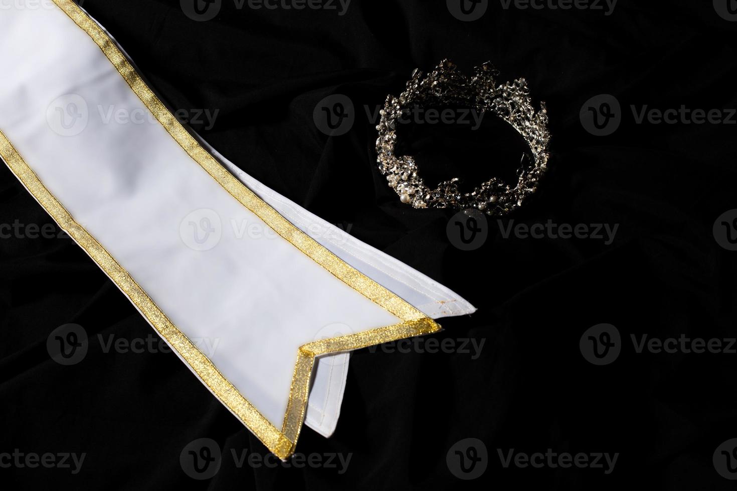 White Gold Winner Sash for Miss Pageant Beauty Contest, empty area for text winner country word, studio lighting abstract dark drapping textile background, Importance Decoration with Diamond Crown photo