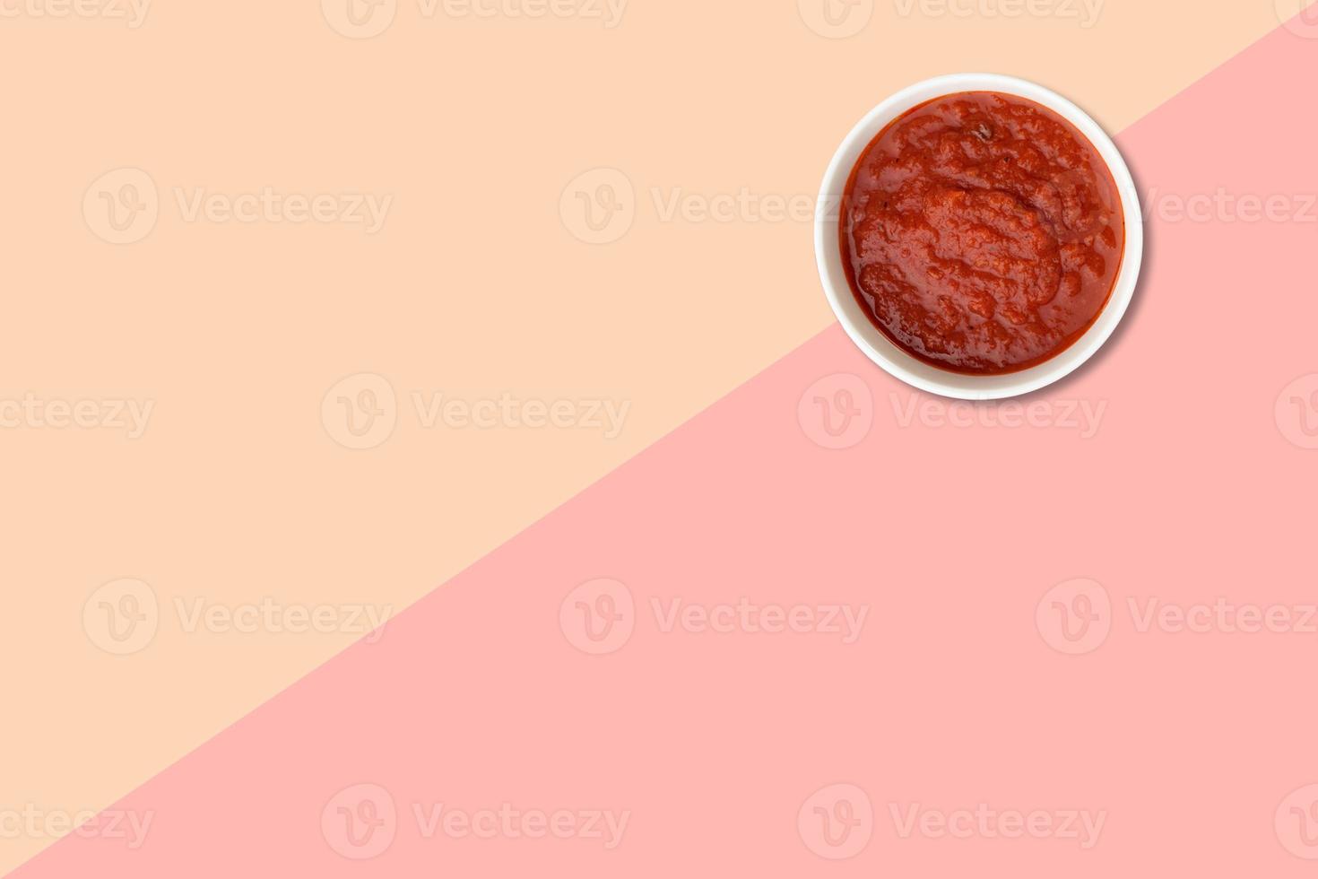 Close up view red tomatoes ketchup isolated on pink background. photo