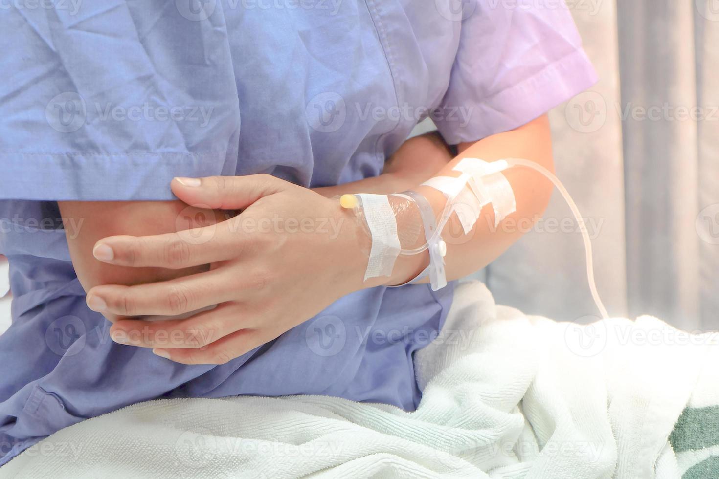 Close up of saline drip in patient's hand . Asian woman with  hospital admission. photo