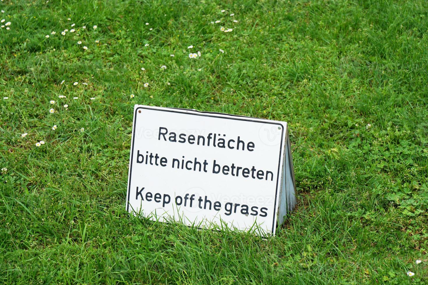 bilingual keep of the grass sign in Germany photo