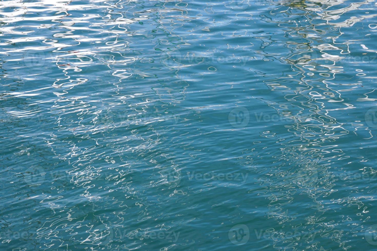 blue water surface with gentle ripples and reflections photo