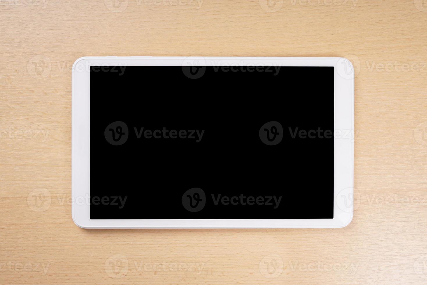 tablet computer with blank display on wooden desk photo