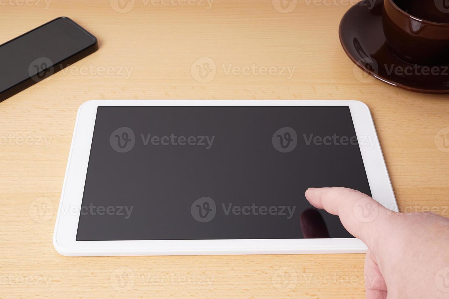 finger touching blank touchscreen on tablet computer photo