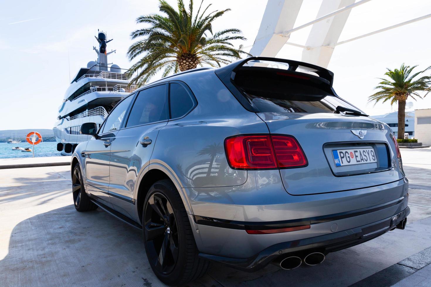 tivat, montenegro - 20 de octubre de 2020, coches bentley bentayga, frente a un megayate astrid conroy de lujo, atracan en un puerto deportivo en la costa adriática. foto