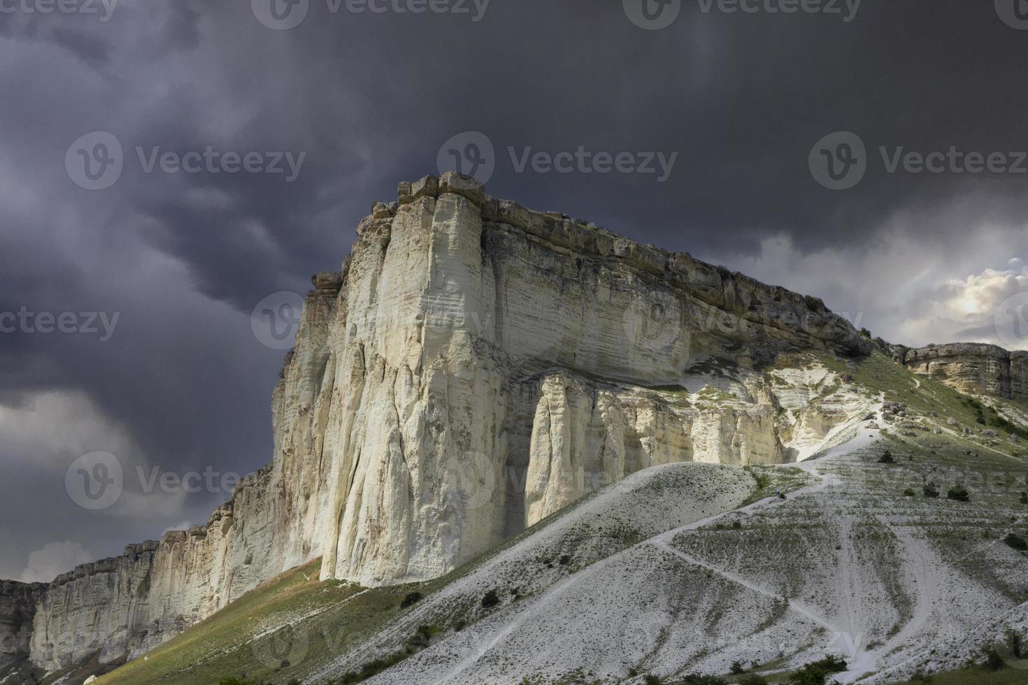 Mountainous, rocky landscape and White Rock peak against a stormy sky. photo