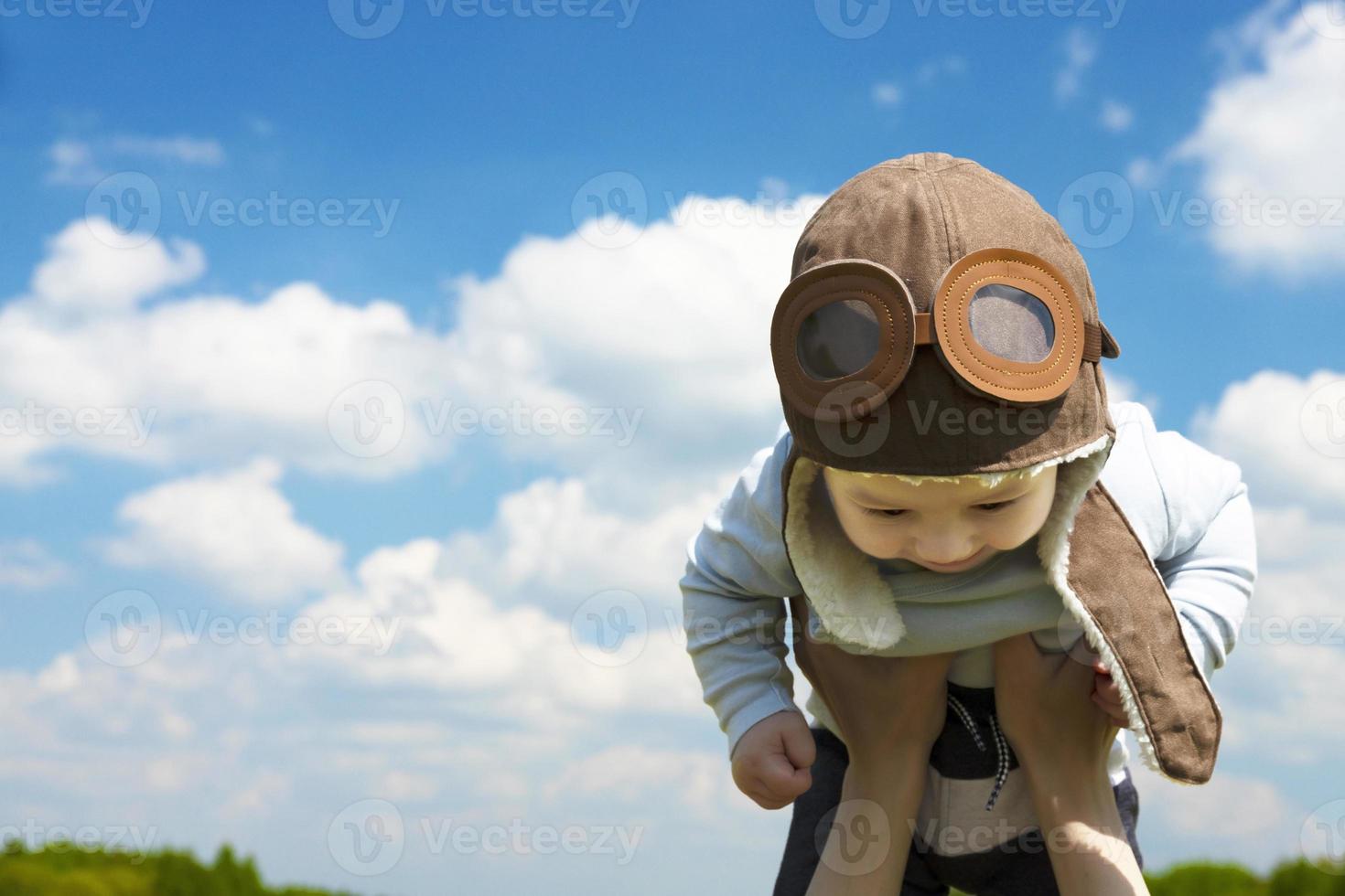 Close-up, Baby pilot, in a pilot's hat, helmet, on the hands of a young, beautiful brunette girl. copy space. photo
