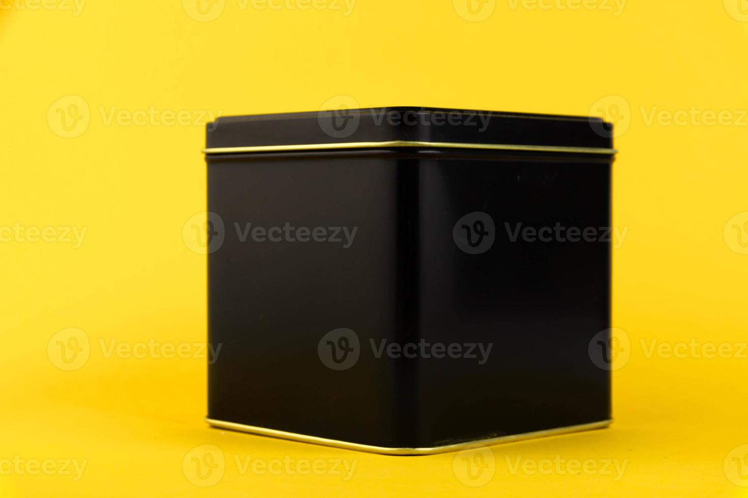 Black metal container, storage jar. isolated on yellow background. Copy space. photo