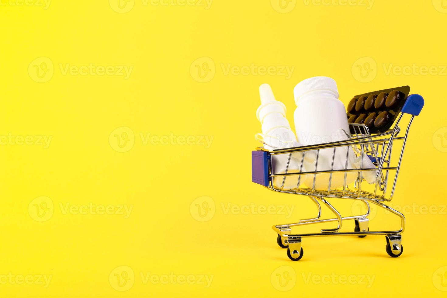 mini carrito de compras vacío, carrito de compras, cesta de compras con medicamentos sobre un fondo amarillo. rfi solicitud de información. copie el espacio foto