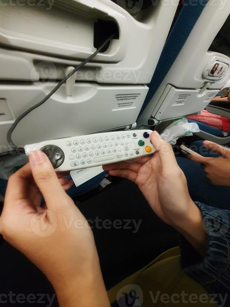 The interior of the passenger seat of a Turkish Airlines plane that has a touch screen for in-flight entertainment. Which is also equipped with a remote controller that also functions as a game stick photo