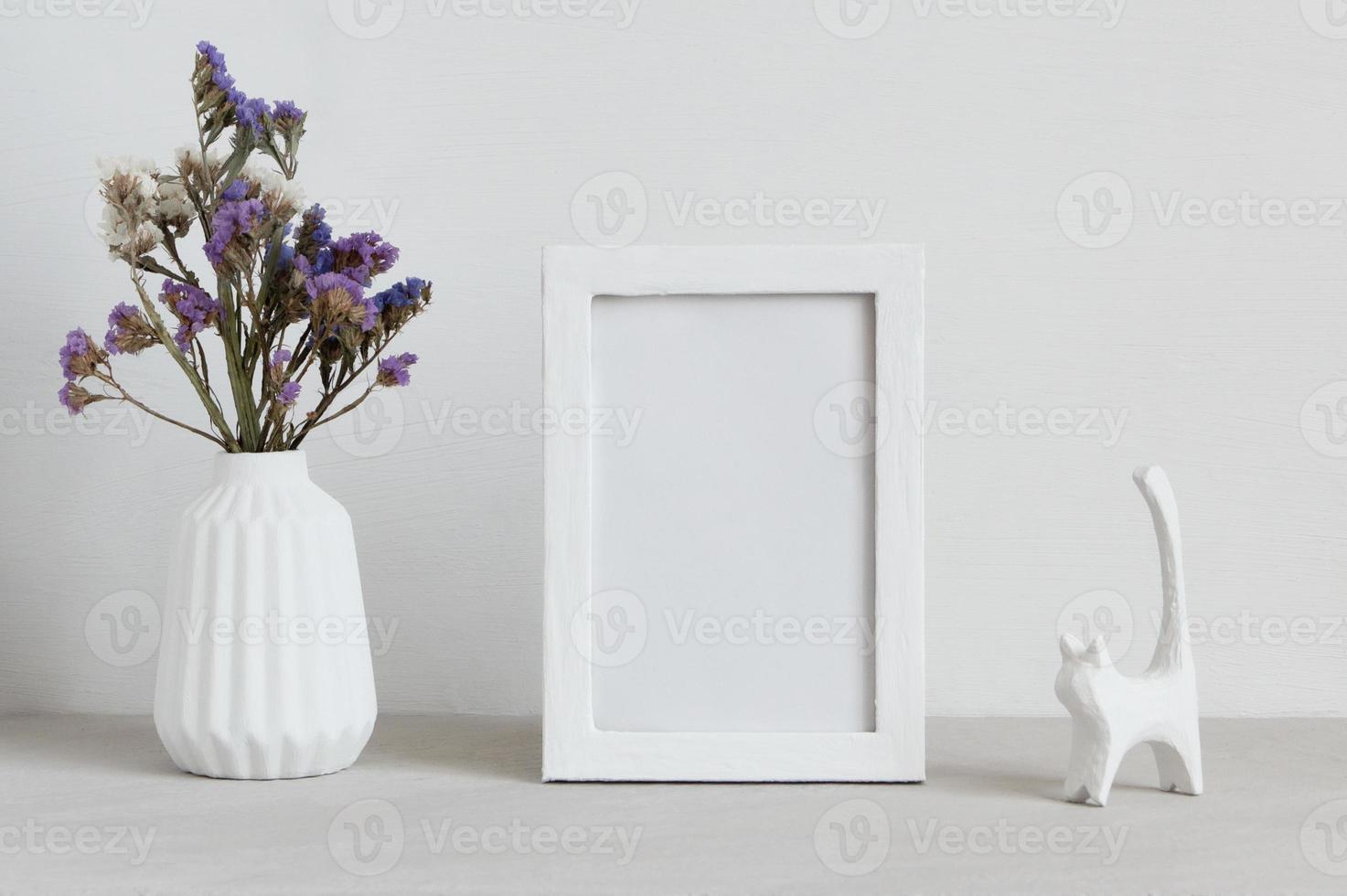 White mockup frame with vase and cat statuette. photo