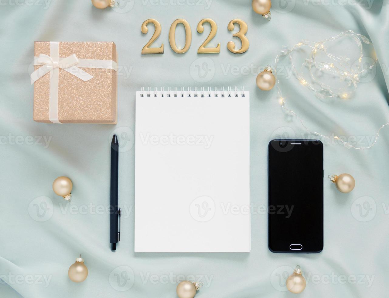 Blank notepad gift numbers 2023. Christmas concert planning, wish list and goals. Top view of holiday delicate mint  background with symbols. photo