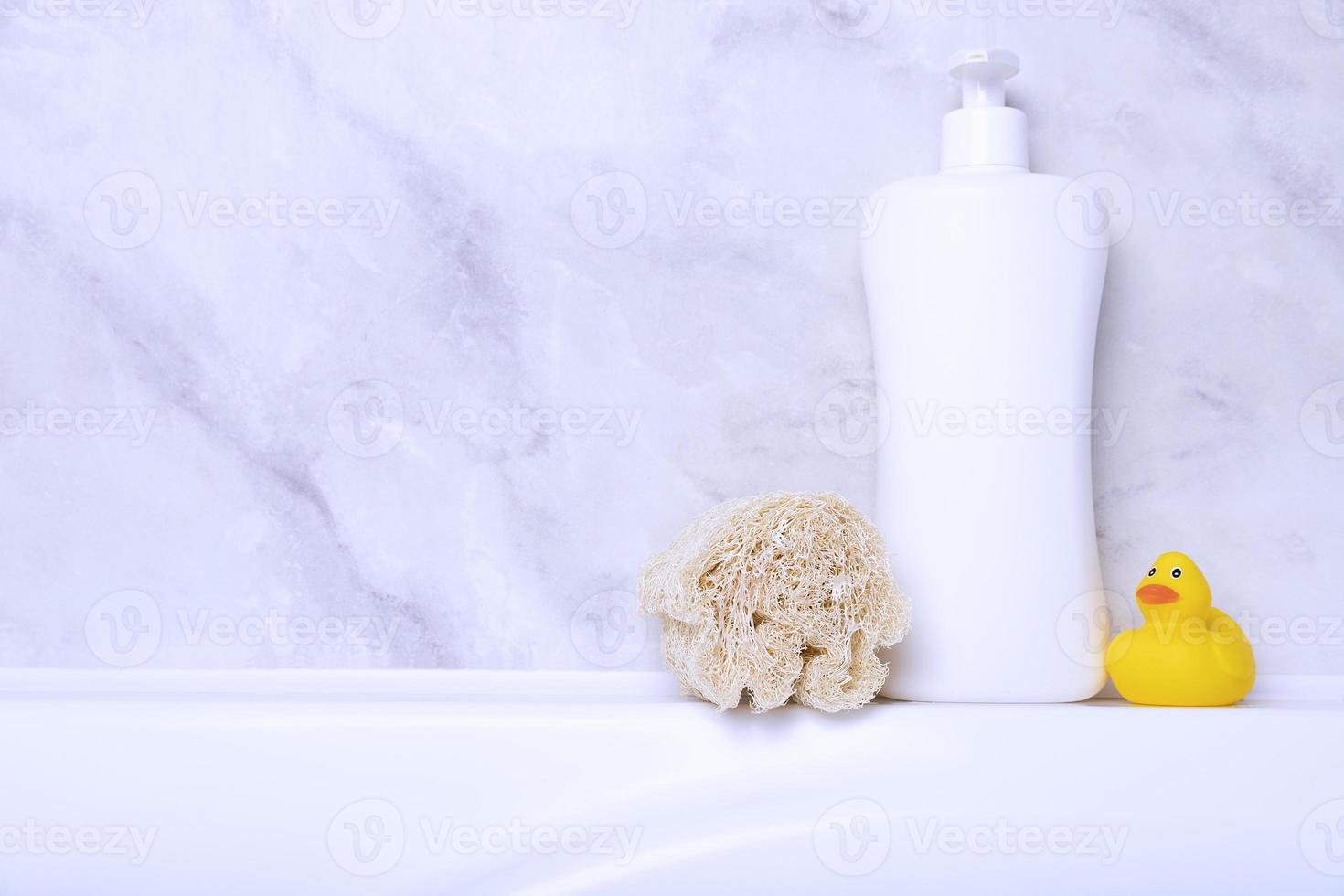 Children's hygiene products concept. Yellow duckling in the bathroom on a background of gray tiles. Copy space photo