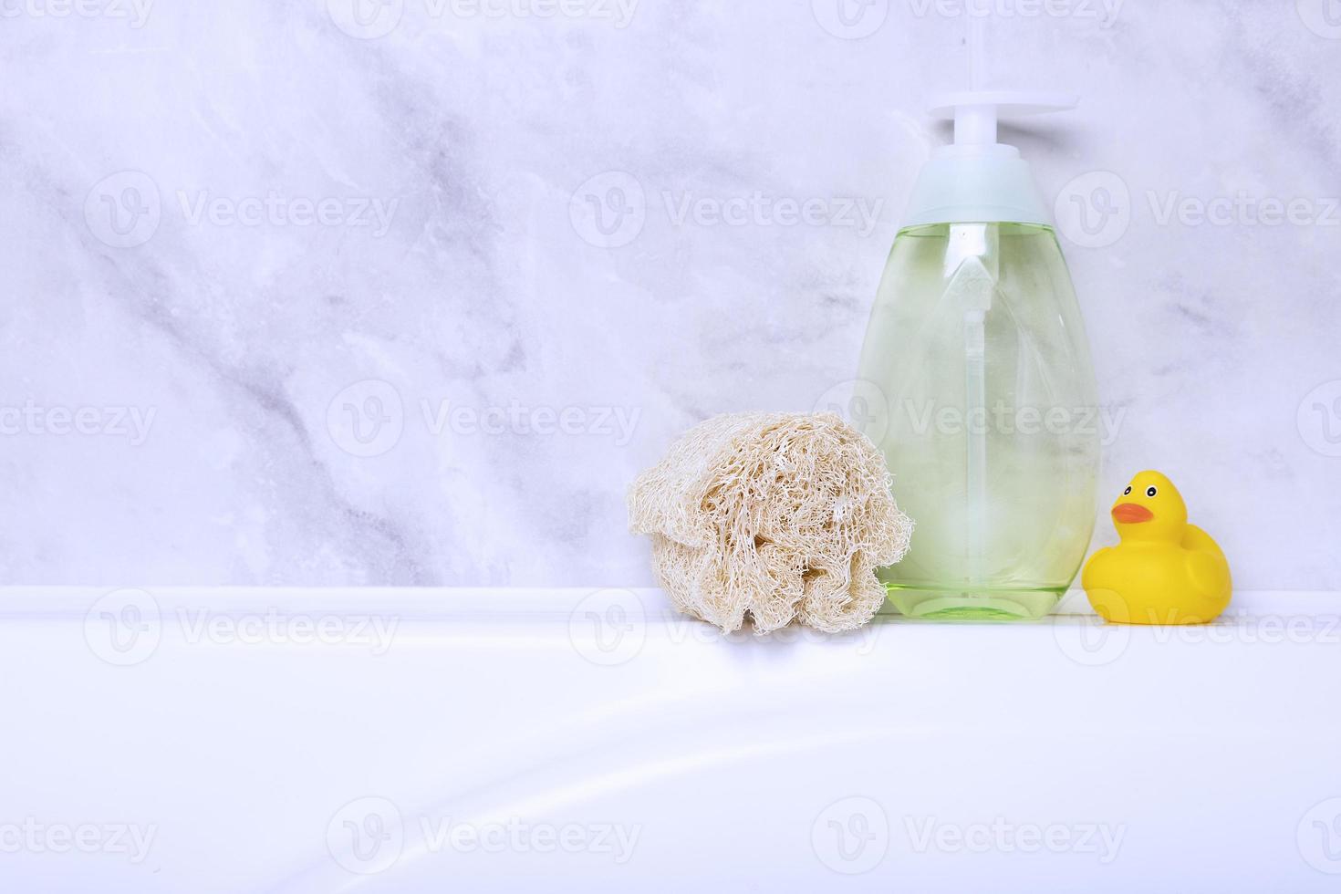 Children's hygiene products concept. Yellow duckling in the bathroom on a background of gray tiles. Copy space photo