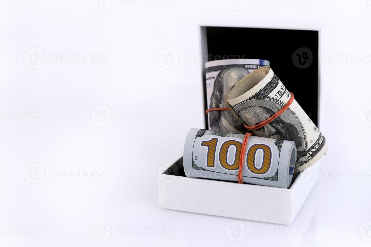 A cash gift in the form of American money rolls in a white gift box. Isolated over white background. Enjoy your money. Copy space. photo