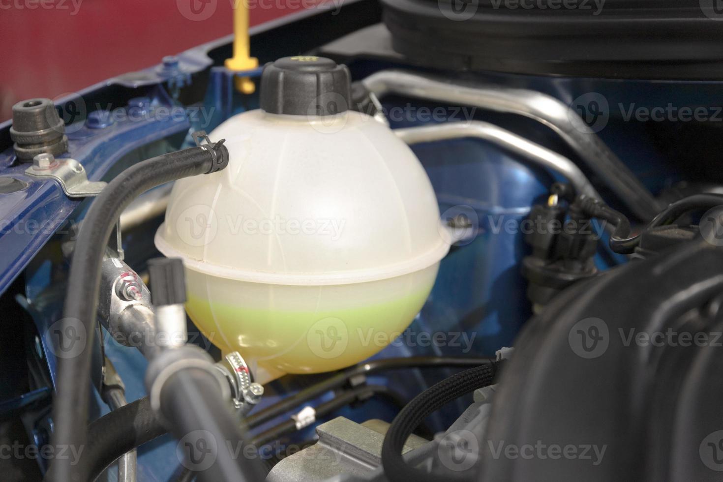Antifreeze coolant tank under the hood of a new engine photo