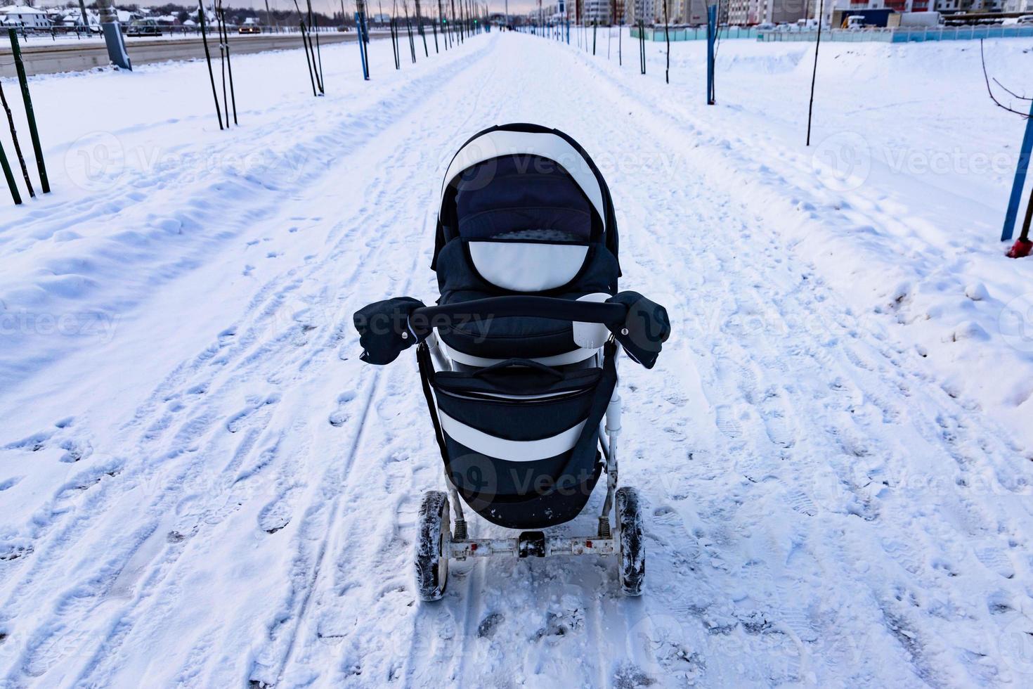 The child sleeps in a stroller in the winter. The concept of winter walks with children in the fresh air. photo