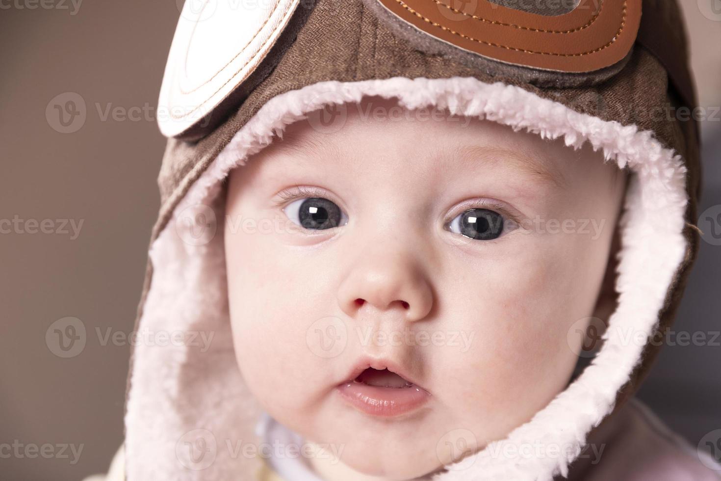 Baby aviator, wearing a pilot hat, close up portrait. photo