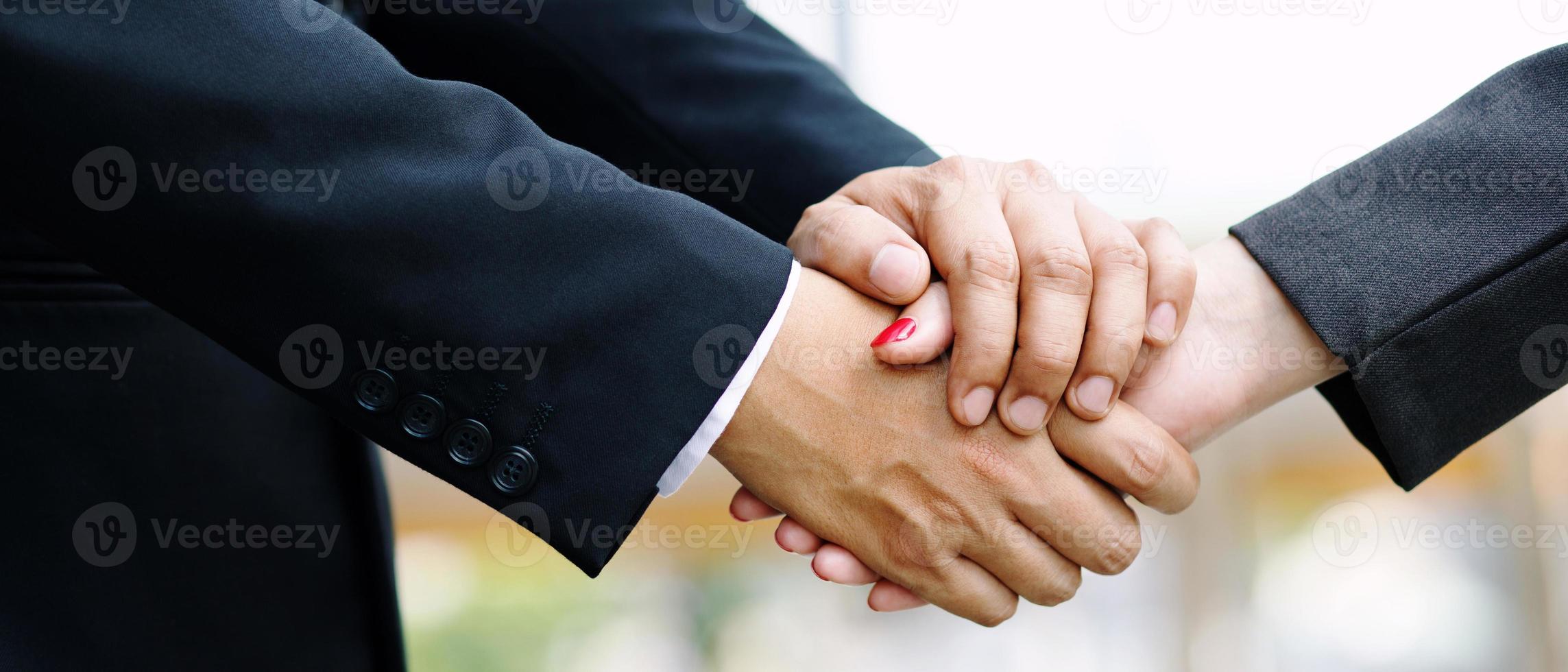 Closeup of a businessman hand shake businesswoman between two colleagues  OK, succeed in business Holding hands. photo