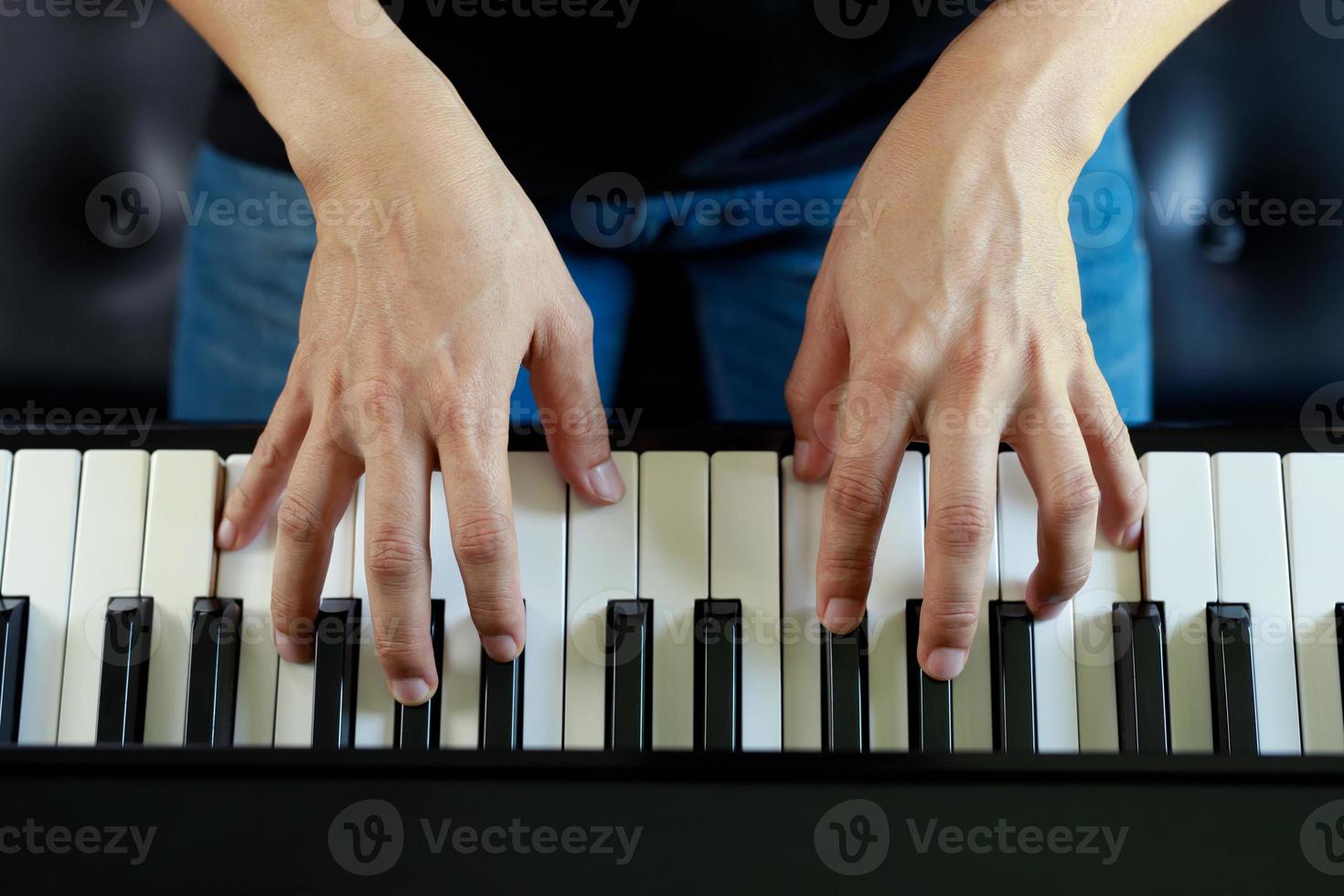 close up of hand people man musician playing piano keyboard with selective focus keys. can be used as a background. photo